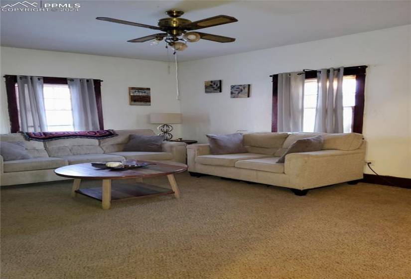 Carpeted living/family room featuring ceiling fan