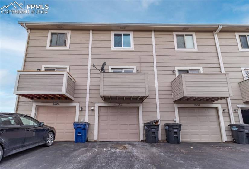 Townhome / multi-family property with a balcony and a garage