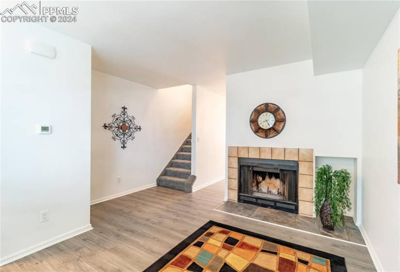 Unfurnished living room featuring light wood-type flooring and a tiled fireplace
