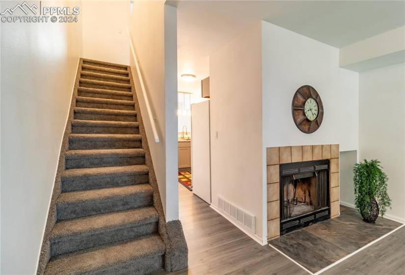 Staircase featuring a tile fireplace, hardwood / wood-style flooring, and sink