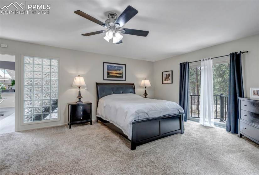Carpeted bedroom with ceiling fan and access to exterior