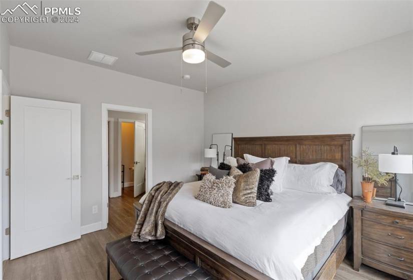 Main Level Primary Bedroom featuring hardwood / wood-style floors and ceiling fan