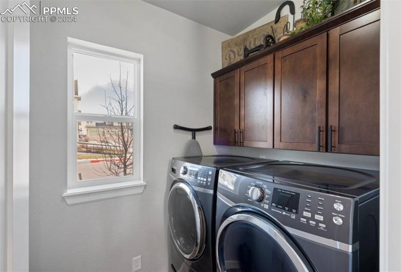 Main Level Laundry area with cabinets and separate washer and dryer