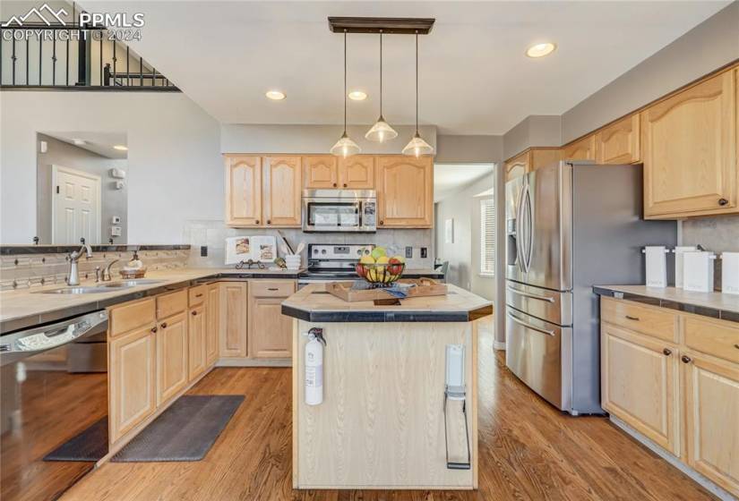 Kitchen with stainless steel appliances, and pendant lighting