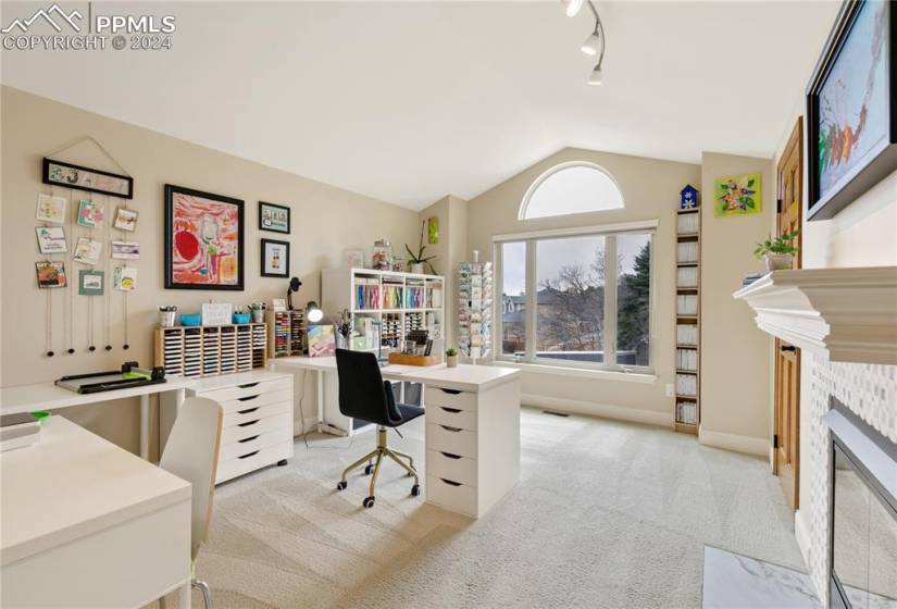 Office area or craft room featuring a tile fireplace, and lofted ceiling and lots of sunshine!