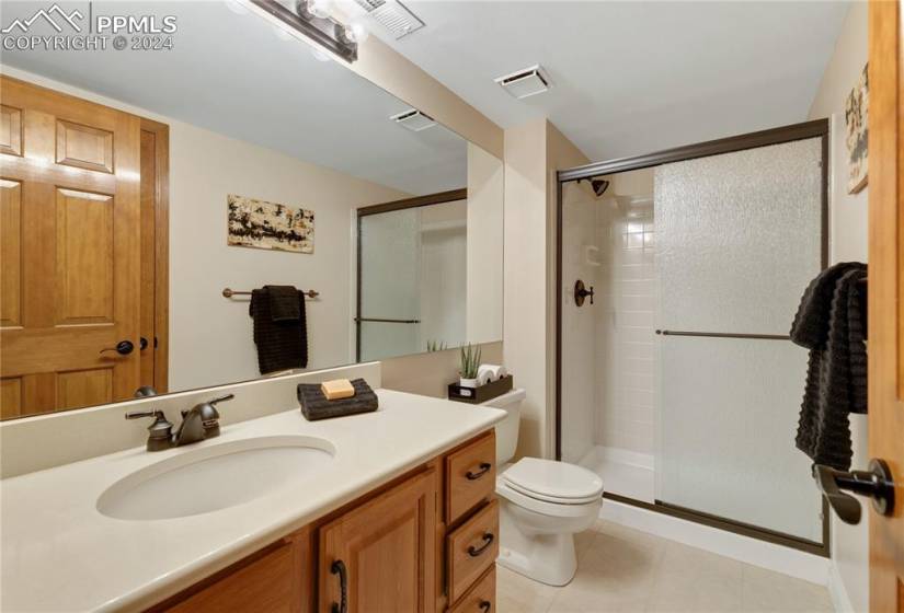 Bathroom featuring vanity, tile floors, and full shower