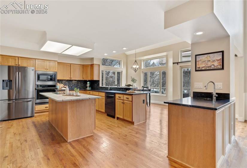 Kitchen featuring kitchen island,  new appliances with  hardwood floors