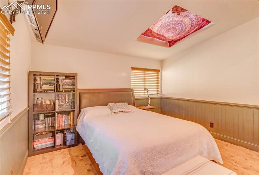 Bedroom featuring a wall mounted AC and light hardwood / wood-style floors