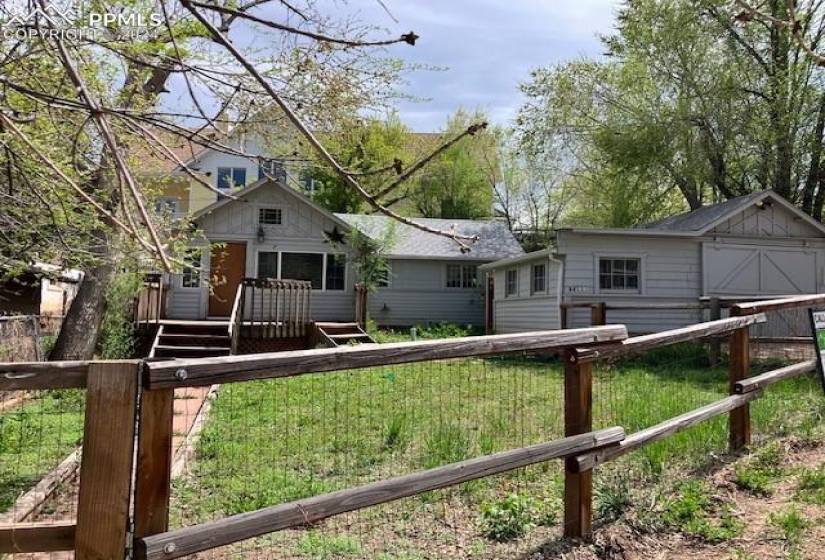 View of front of house featuring a deck, a front lawn, and a shed