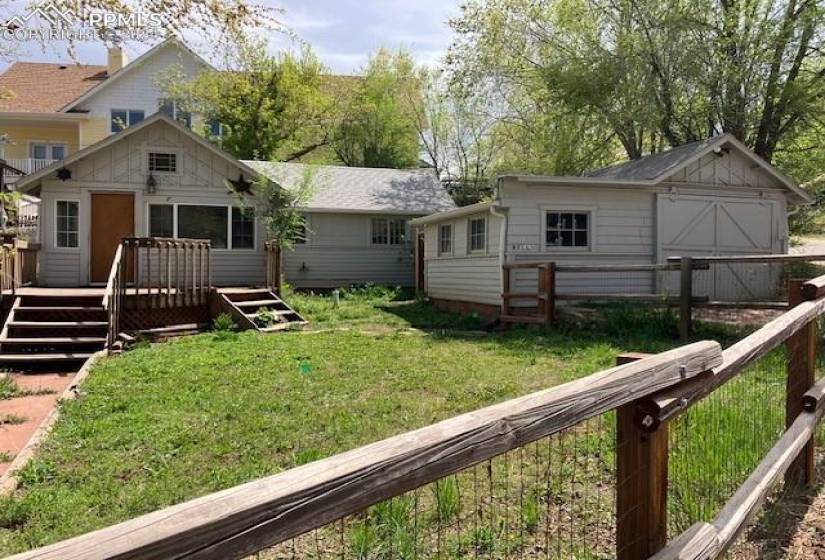 Back of house featuring a wooden deck and a yard