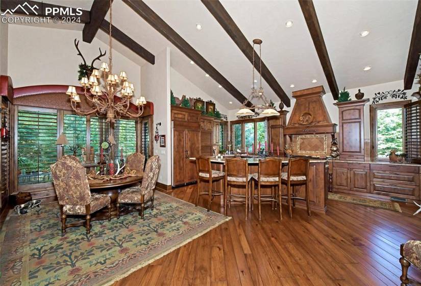 Dining room featuring beam ceiling, an inviting chandelier, and dark hardwood / wood-style flooring