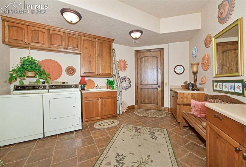 Kitchen featuring a textured ceiling, independent washer and dryer, sink, and dark tile floors