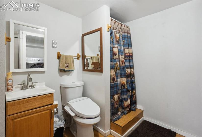 Bathroom with vanity, washer / clothes dryer, and toilet