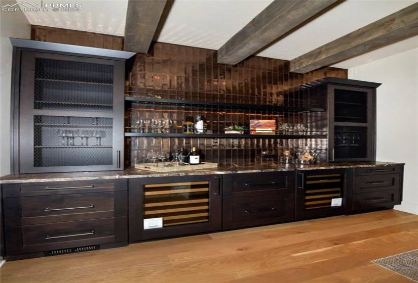 Just some of your bar features include double Sub Zero beverage centers, 2 Sub Zero refrigerator drawers, custom backsplash, display space, stone countertops, and beamed ceiling