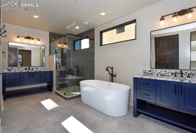 Main Level Guest Bathroom featuring tile flooring, shower with separate bathtub,double vanity