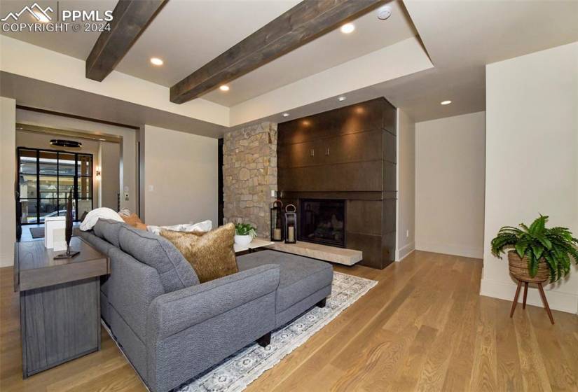 Main floor Family room featuring with oak floors, custom fireplace, beamed ceilings and smart lighting
