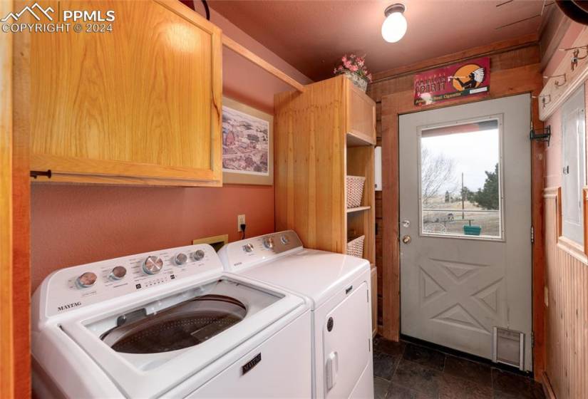 Laundry room featuring washer hookup, cabinets, dark tile flooring, and washing machine and clothes dryer