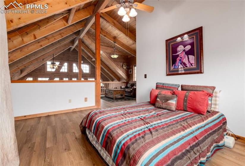 Bedroom featuring wood ceiling, vaulted ceiling with beams, light hardwood / wood-style floors, and ceiling fan