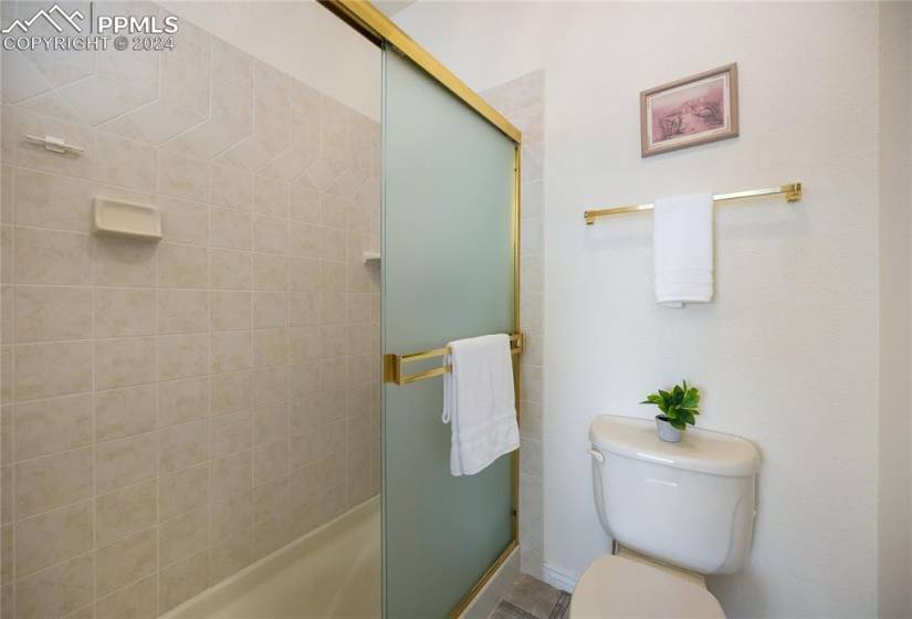 Primary bathroom featuring separate toilet and free standing shower.