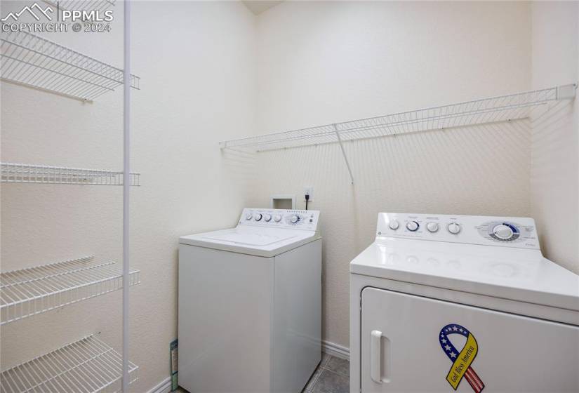 Laundry room on main level with tile floors and washer and dryer