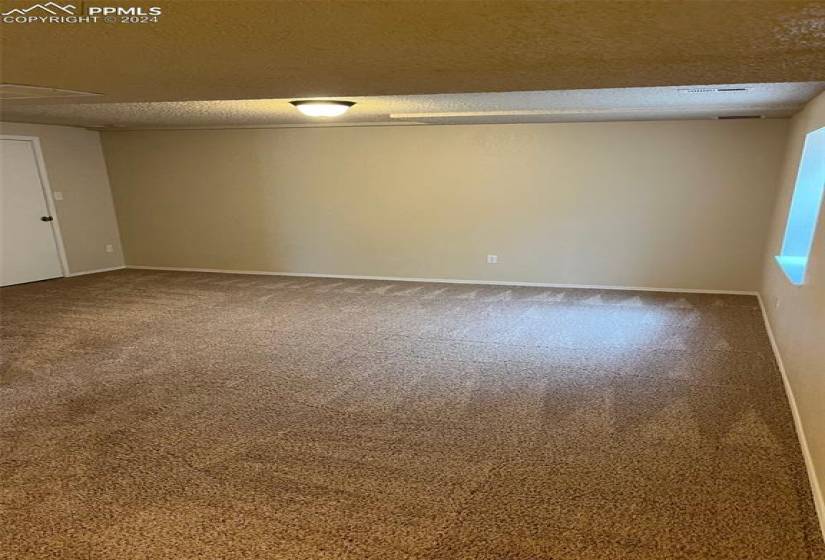 Empty room featuring a textured ceiling and carpet
