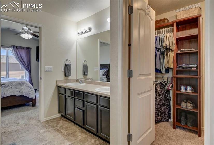 Bathroom featuring oversized vanity, tile floors, ceiling fan, and dual sinks