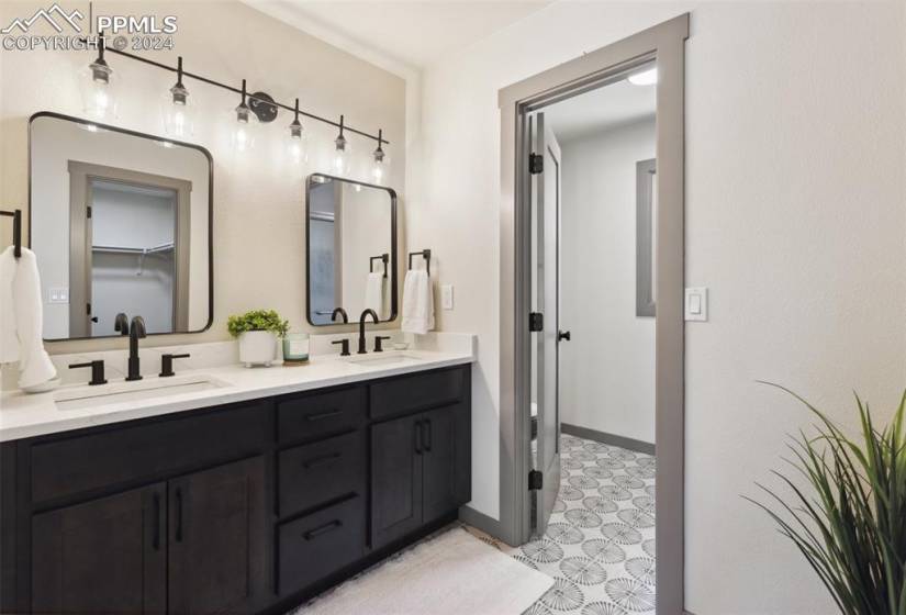 Bathroom featuring double sink, large vanity, and tile flooring