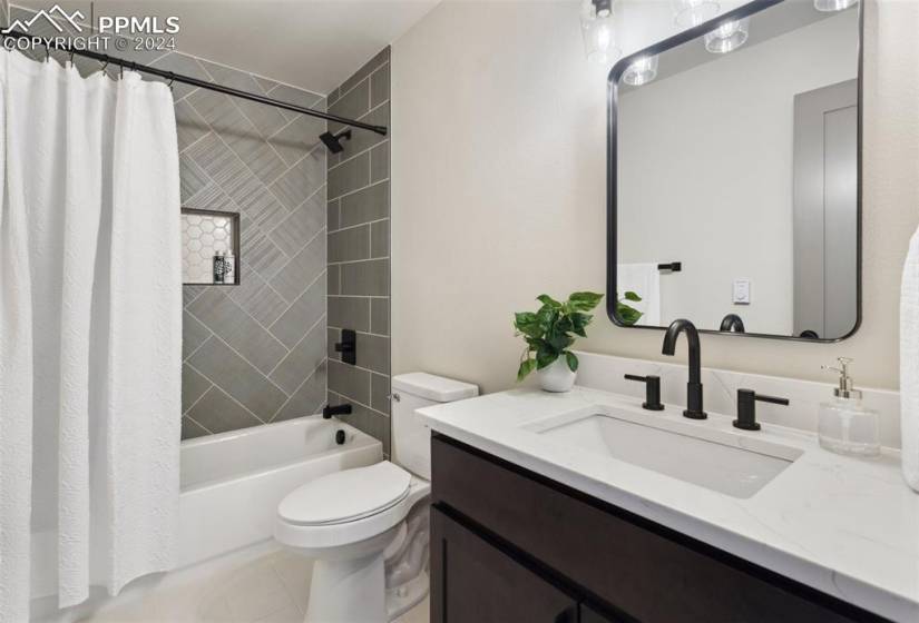 Full bathroom featuring shower / bath combo with shower curtain, toilet, tile flooring, and vanity
