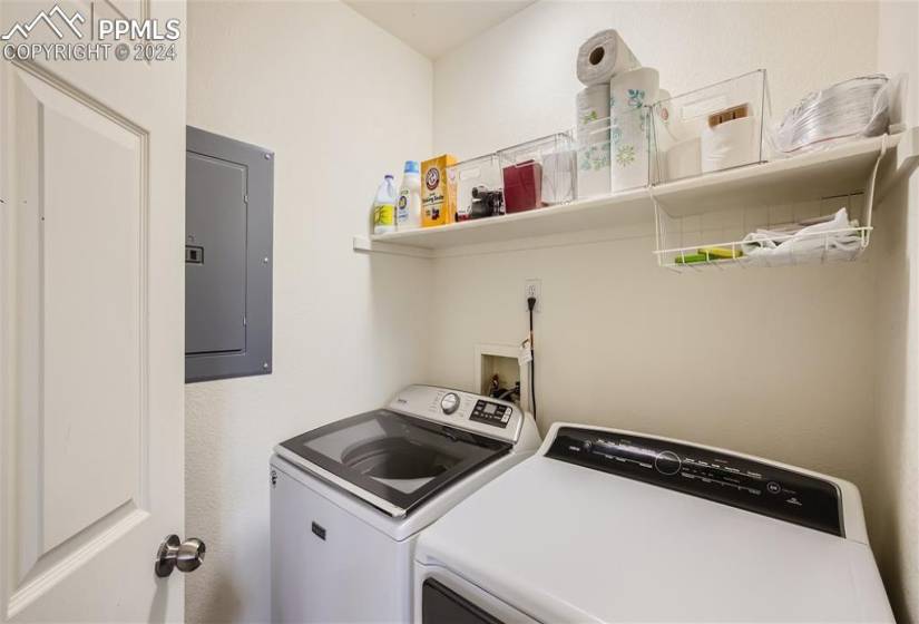 Kitchen with white appliances, sink,  wall chimney exhaust hood, and washer / clothes dryer