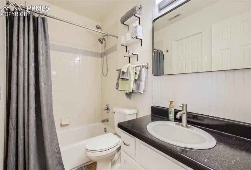 Full bathroom featuring vanity, shower / tub combo, and toilet