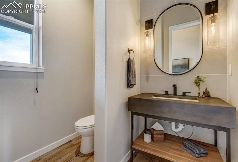 Main Level 1/2 Bathroom with Views of Mountain Range, Hardwood Floors, Floor-to-Ceiling Tile Accent Wall, Hanging Wall Sconces + Freestanding Vanity