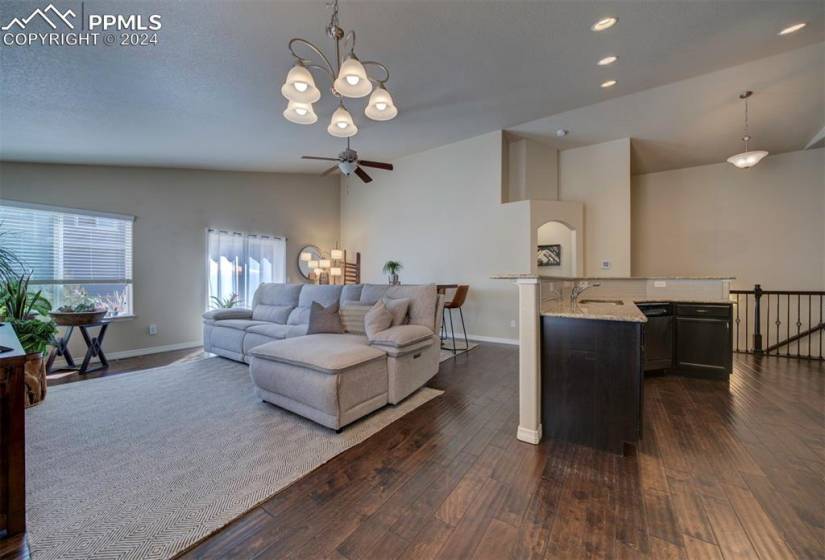 Living room featuring lofted ceiling, dark hardwood / wood-style floors, ceiling fan
