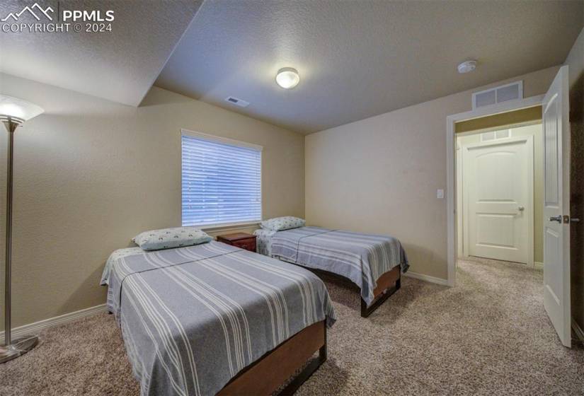 Bedroom with a textured ceiling and light colored carpet