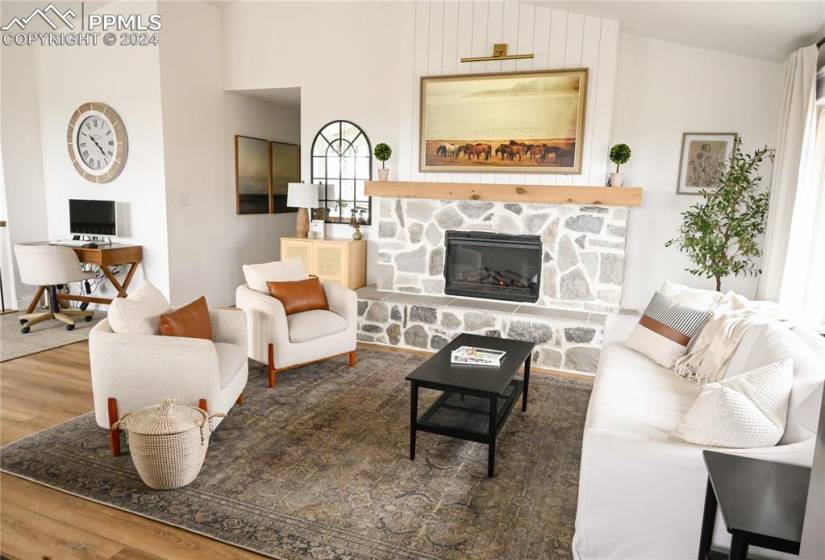 Living room featuring hardwood / wood-style flooring and a stone fireplace