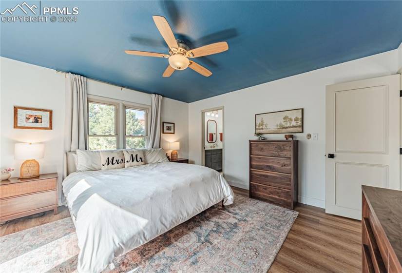 Bedroom featuring ensuite bath, ceiling fan, and dark hardwood / wood-style flooring