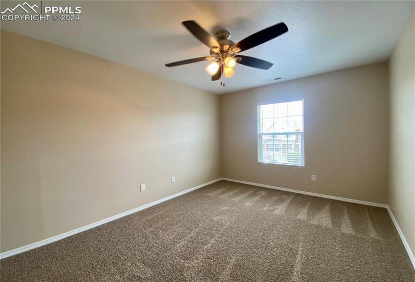 Carpeted 2nd bedroom with ceiling fan
