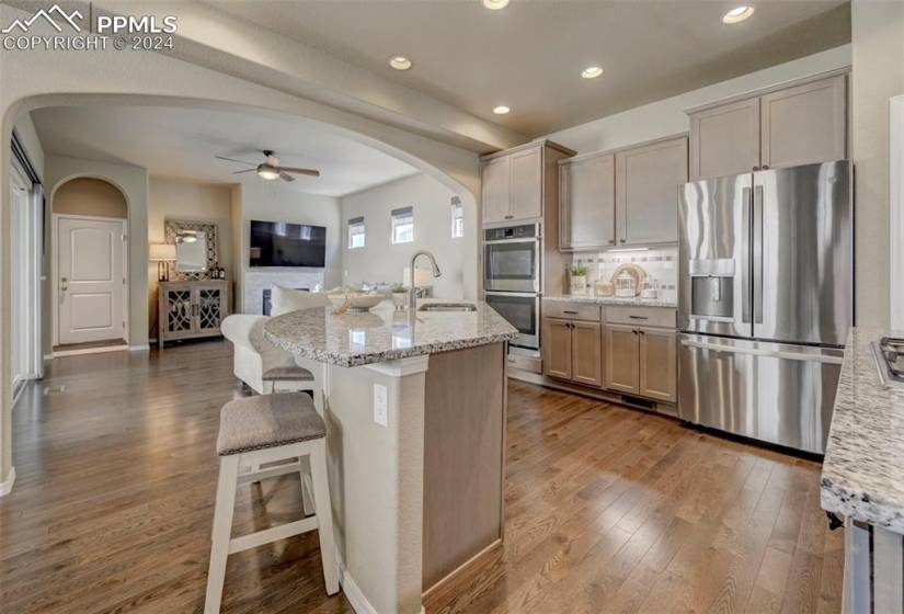Kitchen with ceiling fan, wood-type flooring, appliances with stainless steel finishes, and sink