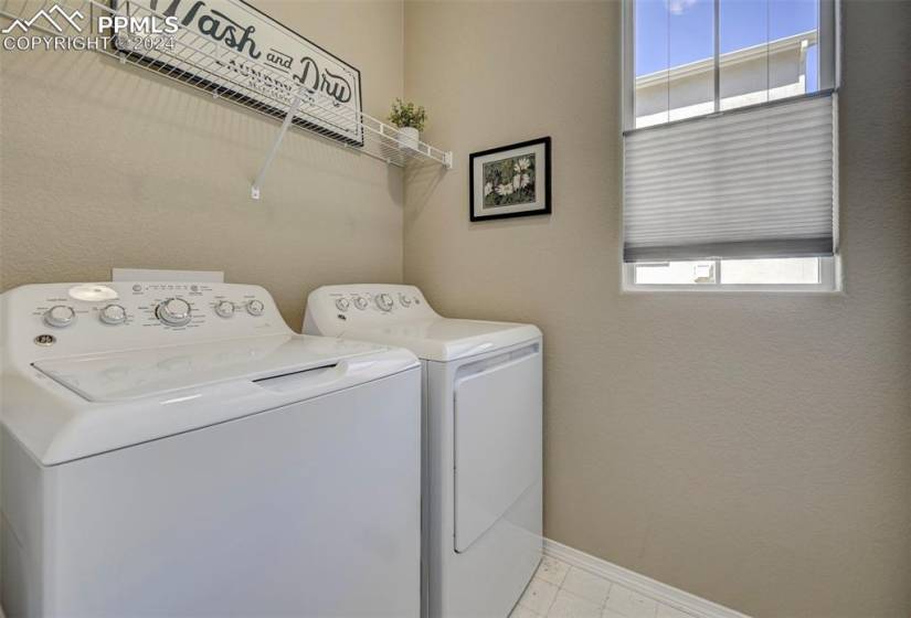 Laundry room featuring washer and clothes dryer and light tile floors