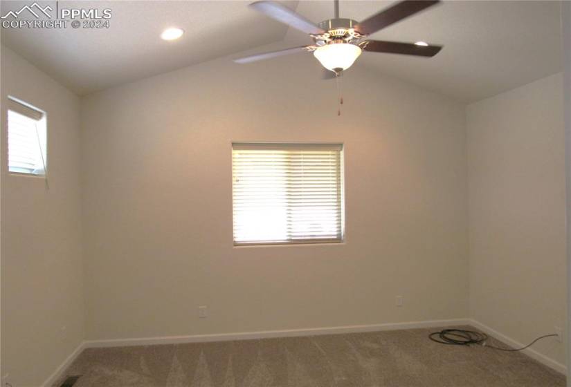 Master bedroom with vaulted ceilings, plenty of natural light and ceiling fan.