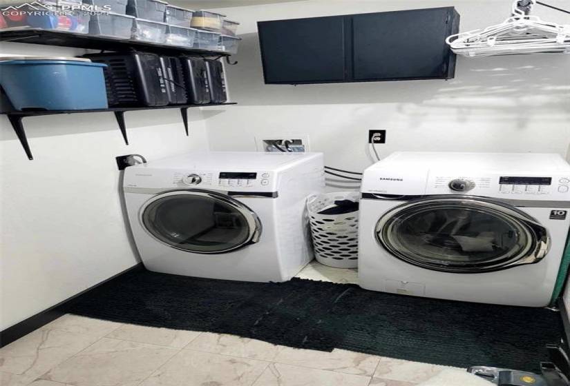 Laundry area with independent washer and dryer, light tile floors, and washer hookup