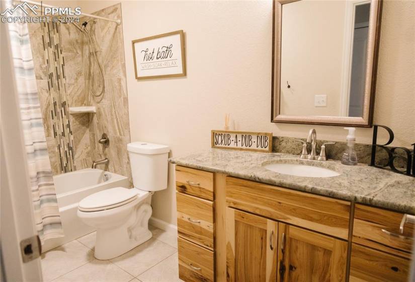 Full bathroom with shower / tub combo with curtain, tile flooring, toilet, and vanity