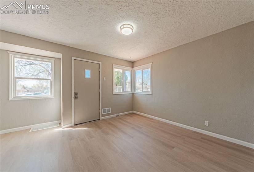 Foyer with light wood-type flooring and a textured ceiling