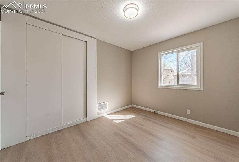 Unfurnished bedroom with a closet and light hardwood / wood-style flooring