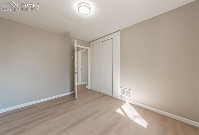 Unfurnished bedroom featuring light hardwood / wood-style flooring and a closet