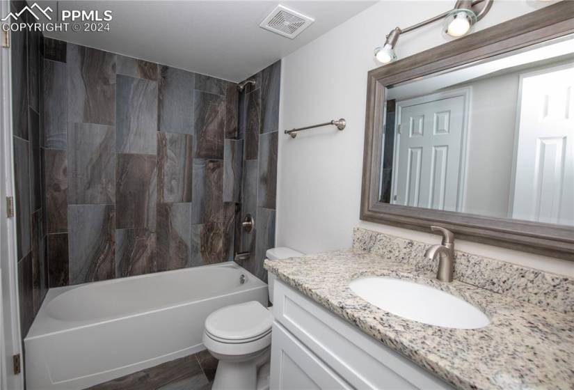 Full bathroom with tile floors, and tiled shower