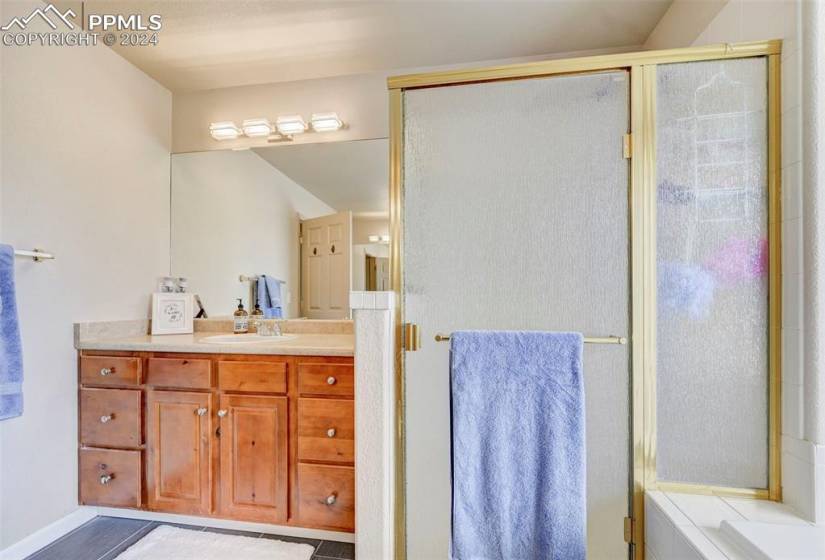 Bathroom featuring vanity, tile floors, and a shower with door