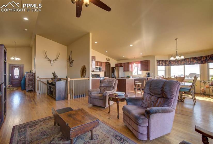 Living room with, light hardwood / wood-style floors, ceiling fan with vaulted ceiling