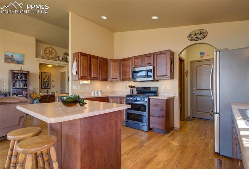 Kitchen featuring light hardwood / wood-style flooring, stainless steel appliances, and a breakfast bar