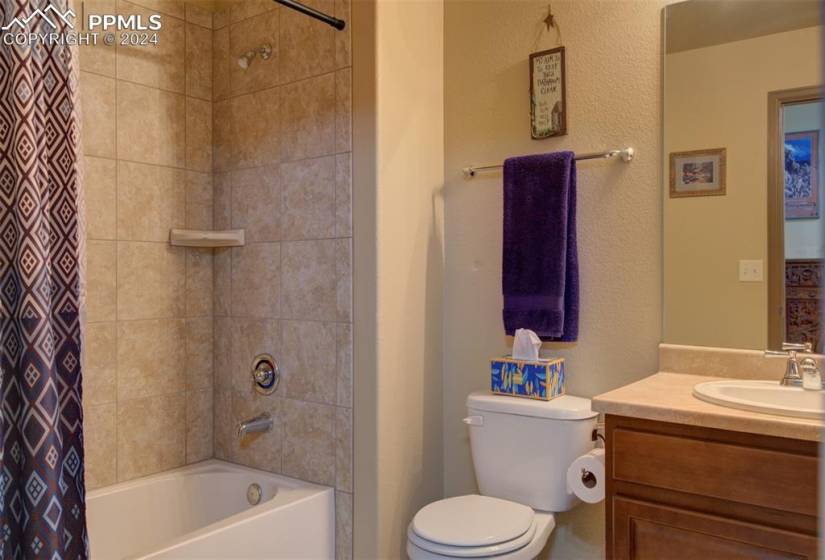 Full bathroom featuring toilet, large vanity, and shower / bath combination