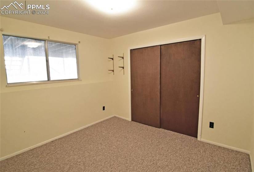 Basement bedroom with closet and carpet.  Bath adjoins.